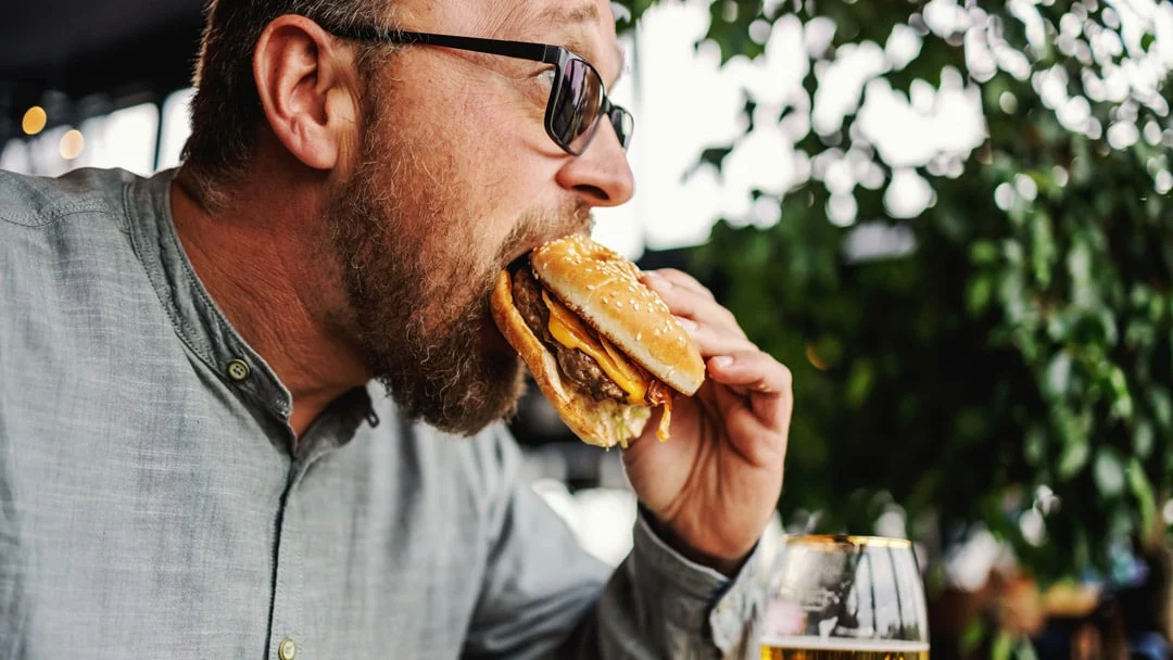 Man eating high sodium hamburger