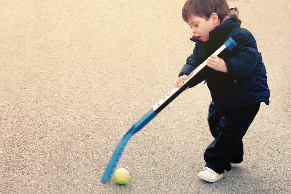 Little boy playing road hockey