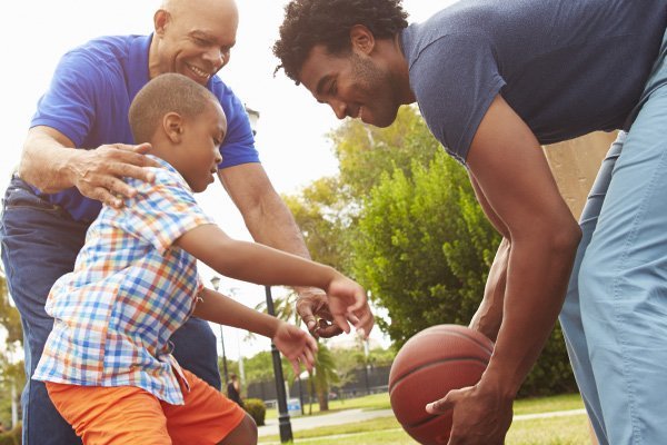 Grandfather, father, and son playing basketball