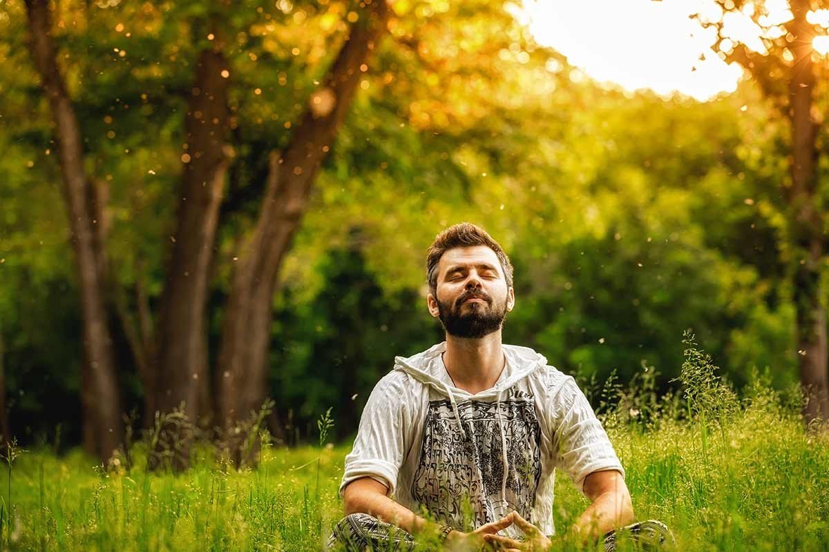 Man meditating on a field of grass