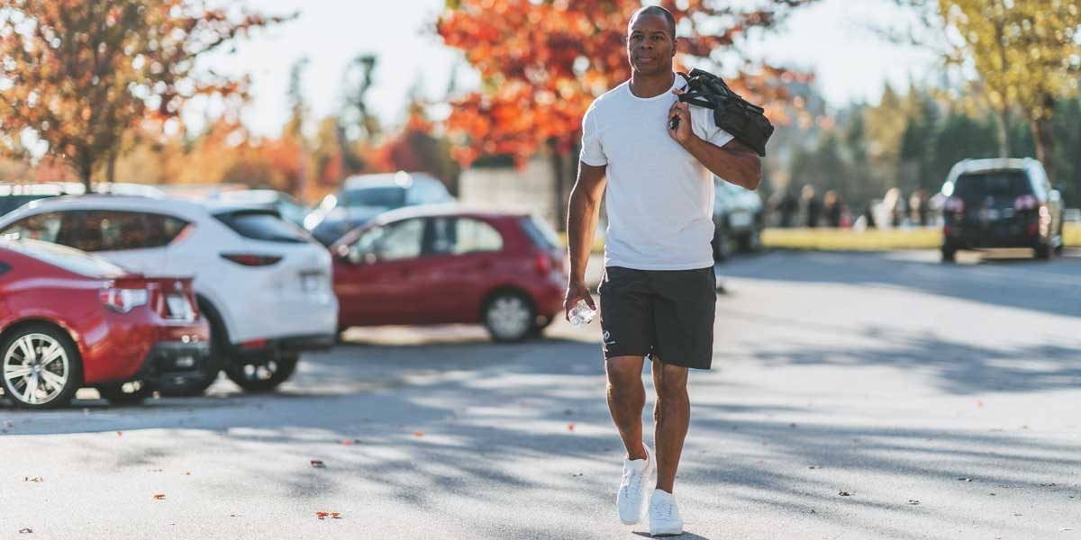 Tommy europe walking in a parking lot holding a bag