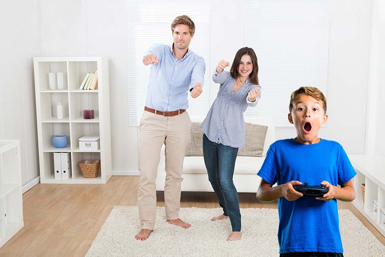 Dad, mon, and son playing an active video game in the living room