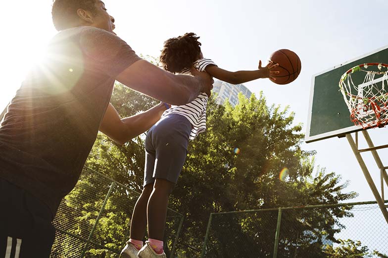 Father and daughter playing basketball