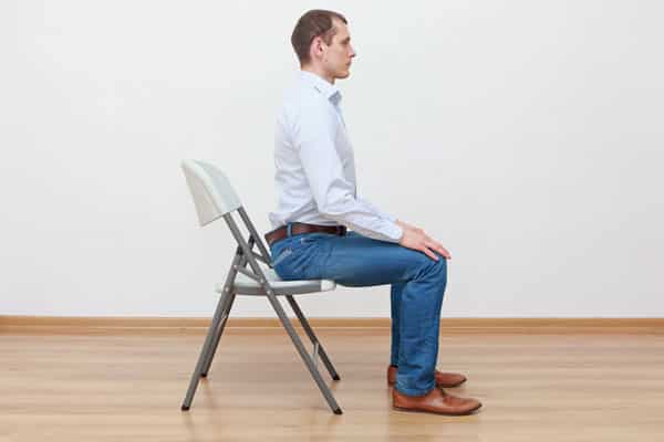 Man sitting upright in chair