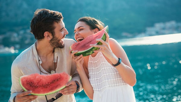 Two people eating watermelon for hydration