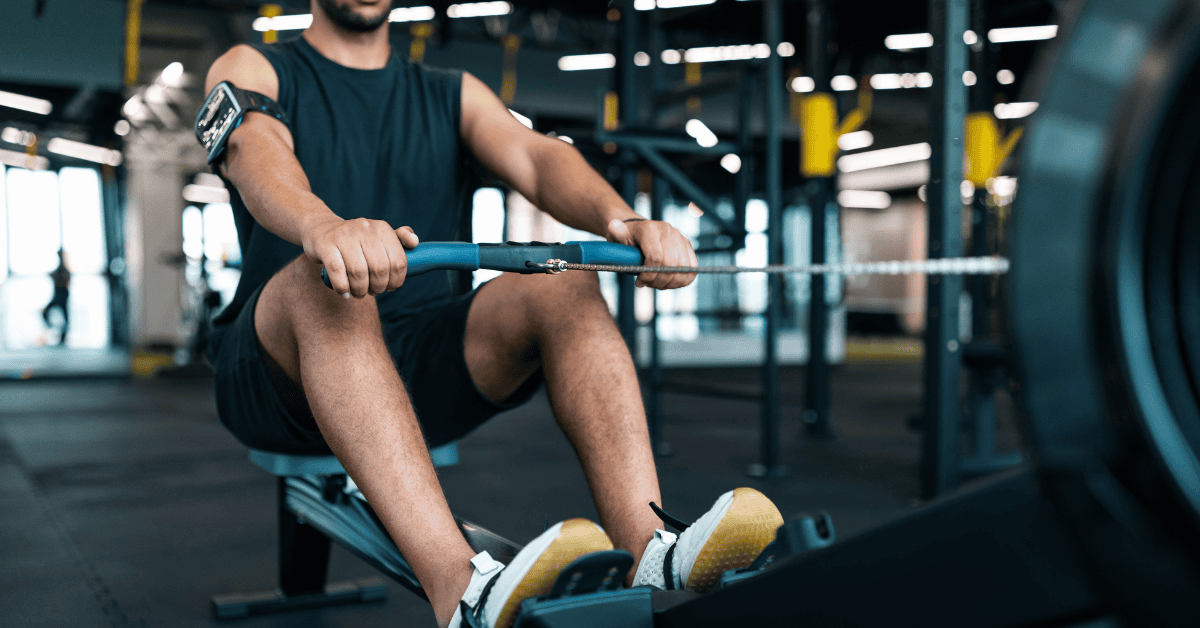 man using rowing machine in gym