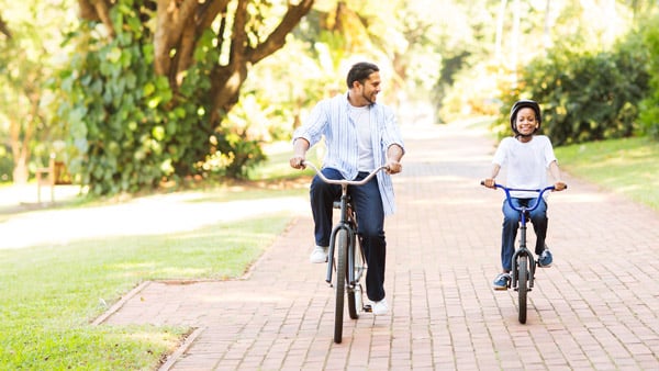 Man riding bike with kid