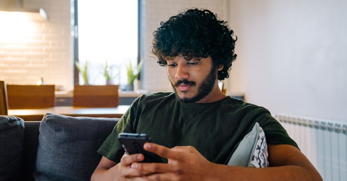 guy looking at phone on the couch