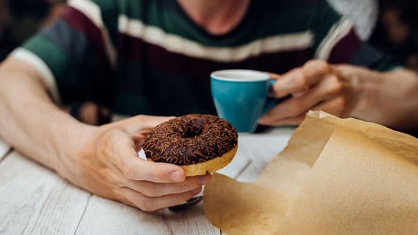 Man eating unhealthy donut