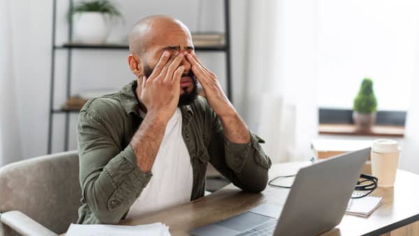 Overwhelmed man sitting at desk