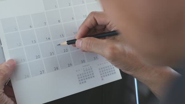 Man marking a calendar with a pencil