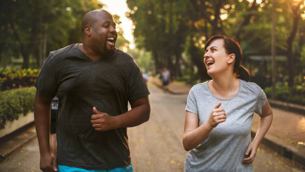 Man and woman jogging and laughing