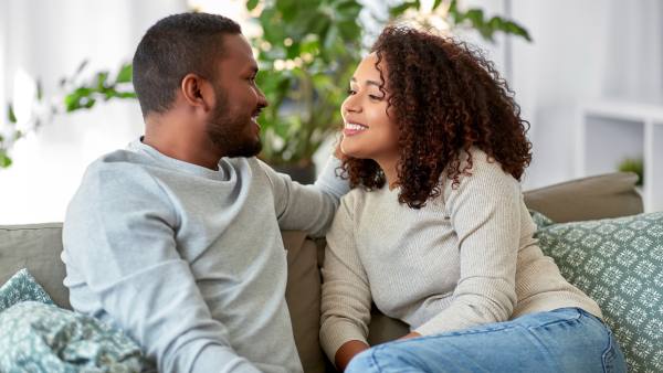 Couple laughing together on a couch