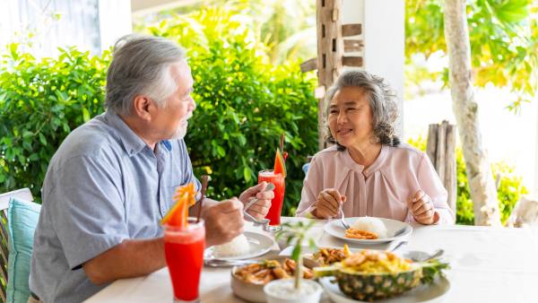 Older asian couple eating healthy meal outside