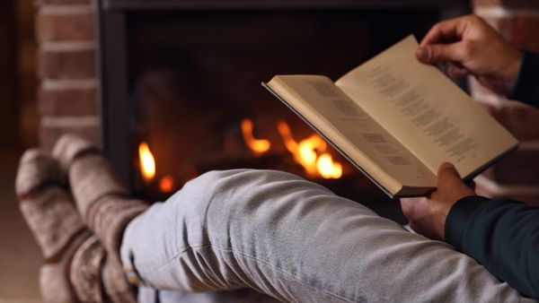 man reading by fireplace